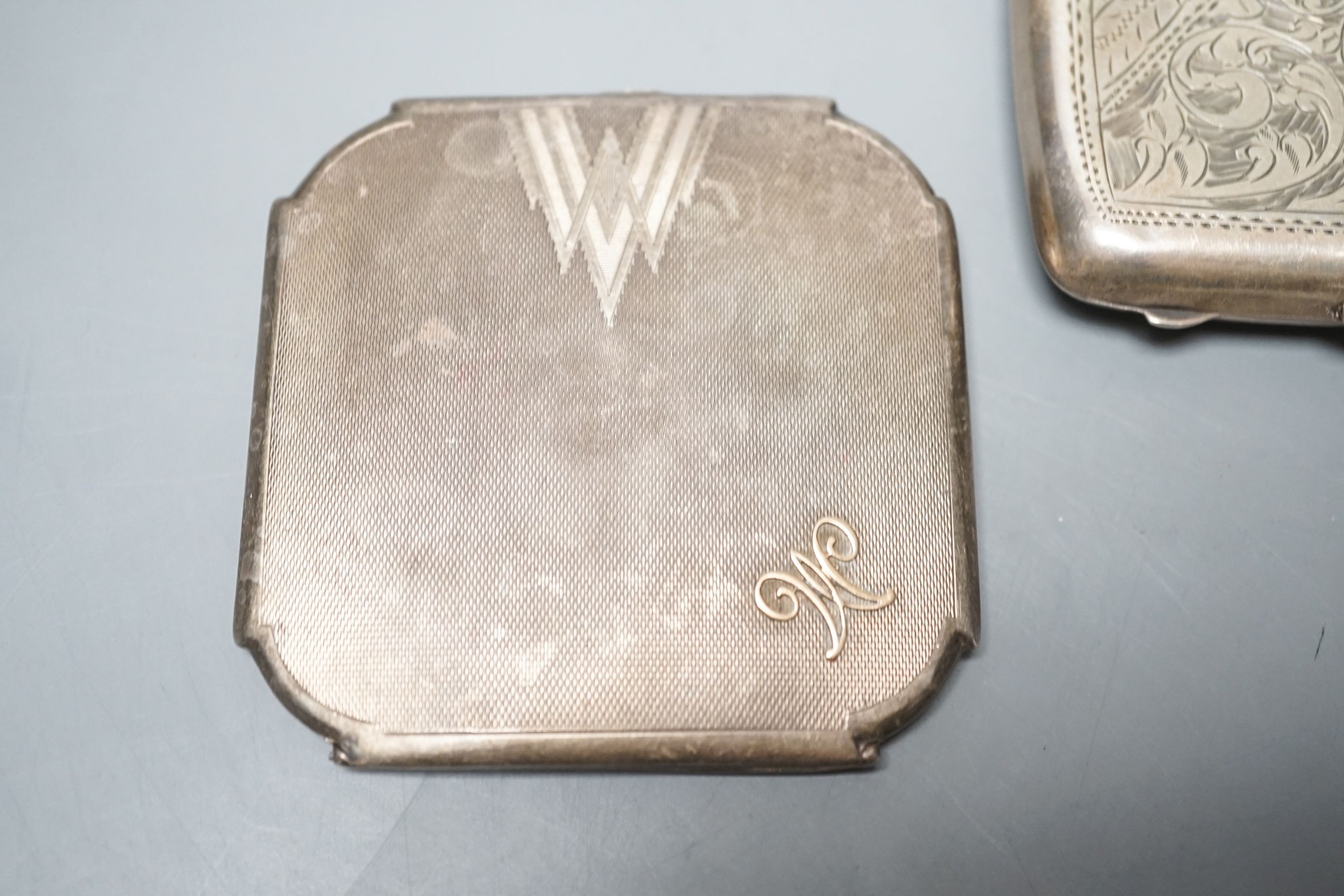 An engine turned silver compact, 83mm and a silver cigarette case.